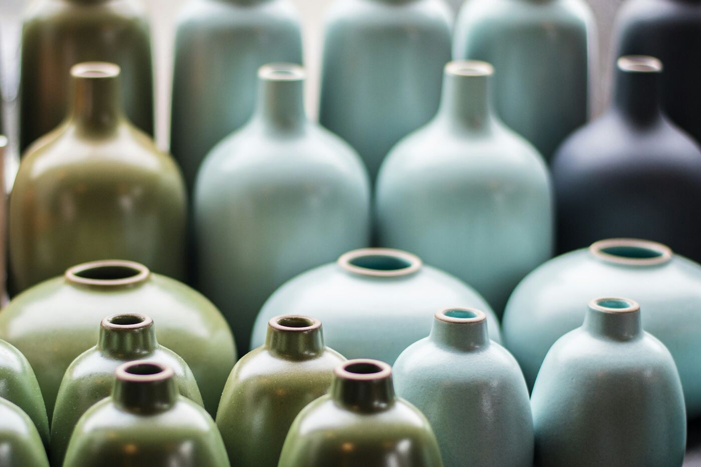 Rows of glazed bottles in greens and blues