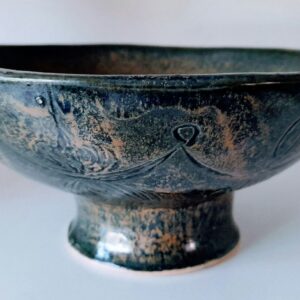 A deep blue glazed bowl on a small foot